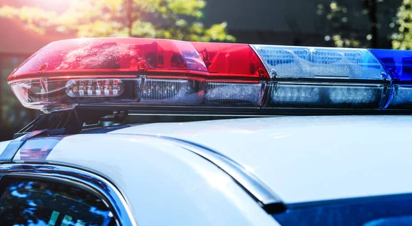 Departamento de policía en plena actividad. Luz roja parpadeante de un coche patrulla de policía el domingo. Día patrullando la ciudad con luces parpadeantes apagadas. Sirena de seguridad del vehículo policial canadiense . — Foto de Stock