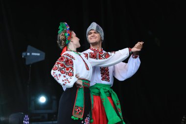 Beautiful Ukrainian dancing groups from United States and Canada perform at Montreal Ukrainian Festival. Young dancers in traditional costumes dancing on stage during the Ukrainian national holiday. clipart