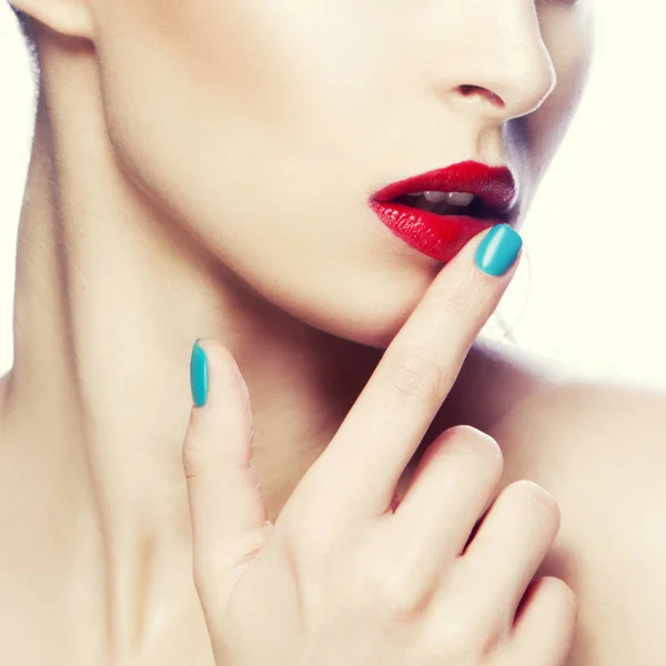 红色嘴唇和蓝色指甲油妇女的被裁剪的画像 — 图库照片
