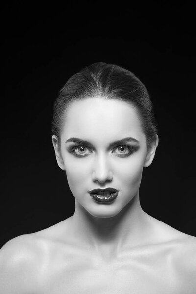 young woman with dark lips posing on black background