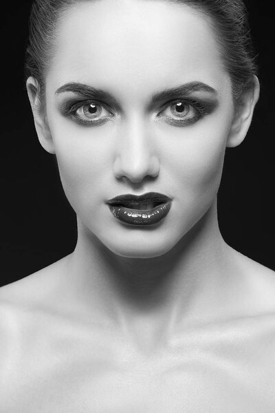 young woman with dark lips posing on black background