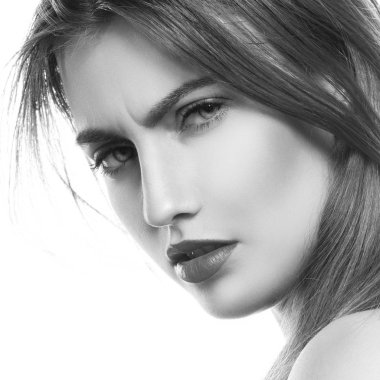 Yüzüne ışık arka plan üzerinde negatif ifade olan esmer kadın portresi