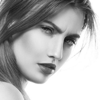 Yüzüne ışık arka plan üzerinde negatif ifade olan esmer kadın portresi