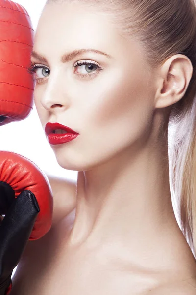 Young woman with red lips makeup and boxing-gloves on white background