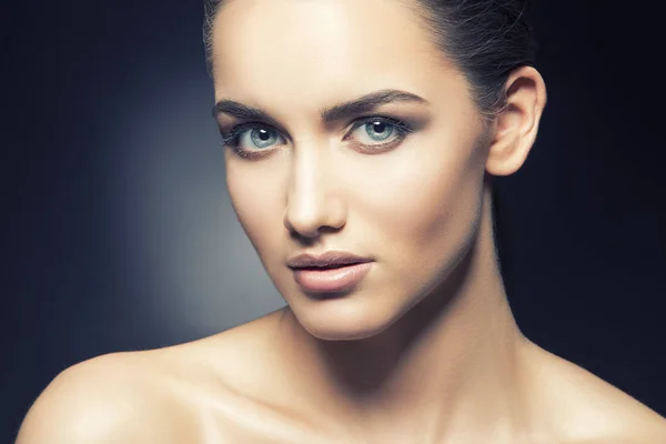 Portrait of young woman with natural makeup on black background