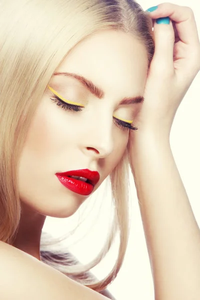 Portrait of woman with modern yellow eyeliner and red lips