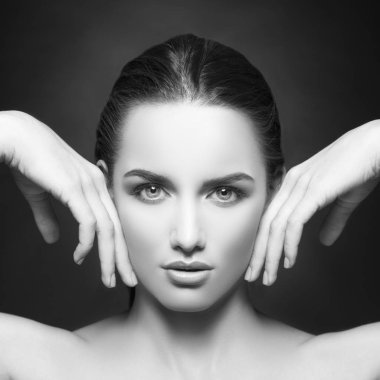 yanakları eller tarafından dokunmaktan ve kameraya koyu arka plan üzerinde seyir doğal makyaj ile kadın portresi 