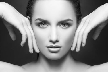 yanakları eller tarafından dokunmaktan ve kameraya koyu arka plan üzerinde seyir doğal makyaj ile kadın portresi 