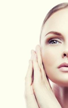 Doğal makyaj ve yüz beyaz arka plan üzerinde yakınındaki elleri ile genç kadın portre yarısı