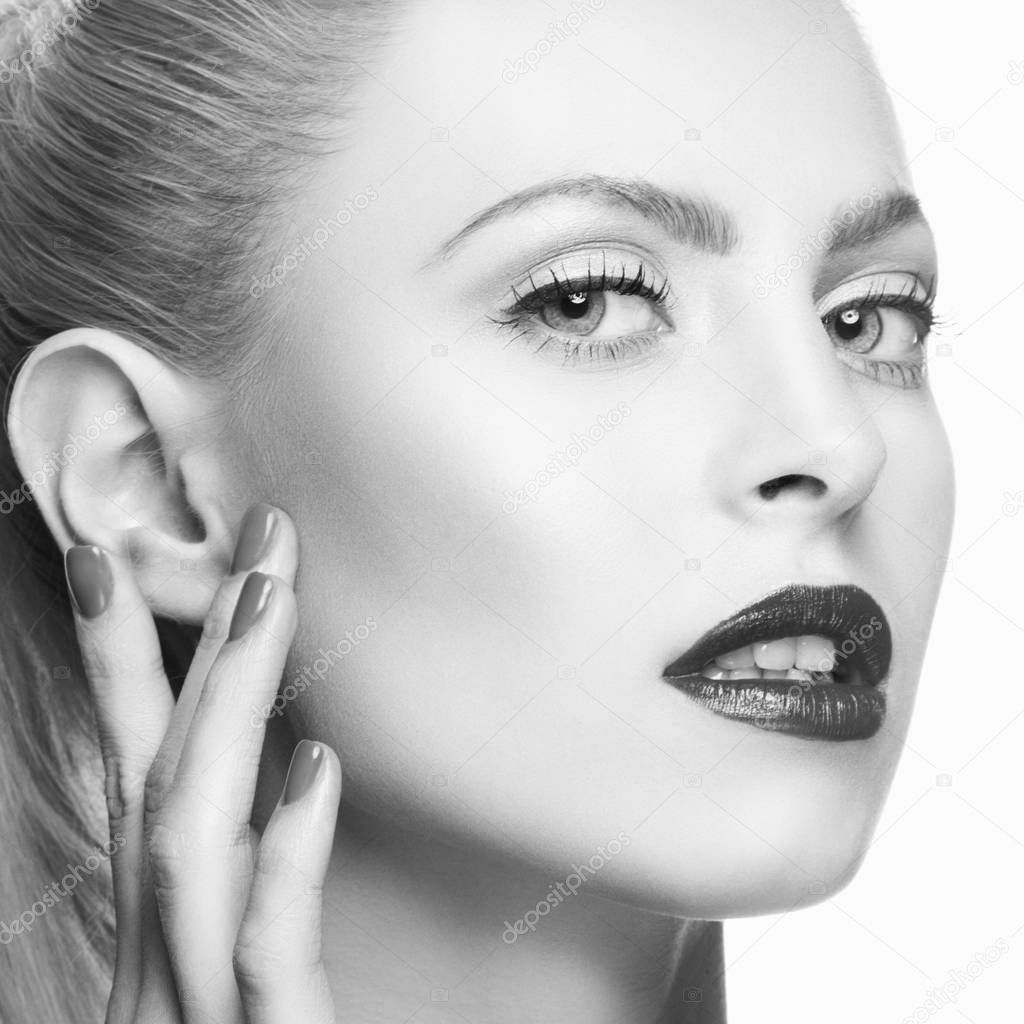 Portrait of woman with dark lips and nail polish on white background