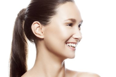 Beyaz arka plan üzerinde izole doğal makyaj ile genç gülümseyen kadın portresi