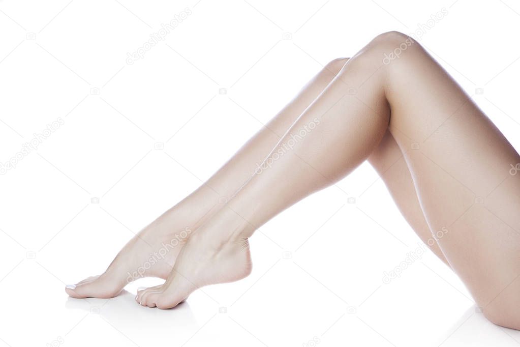 Side view of female feet with white manicure on white background