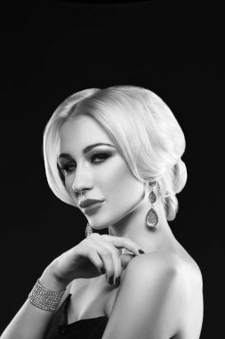 Siyah arka plan üzerine poz şık makyaj ve moda aksesuarları ile sarışın genç kadın portresi