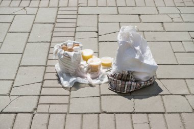Kaldırımda yumurta, ev yapımı organik bal ve plastik damalı çanta ile Kova 
