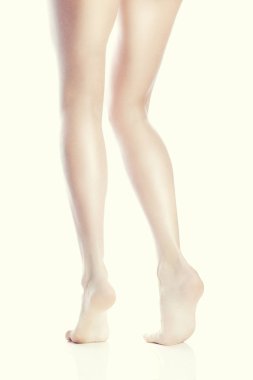 Beyaz arka plan üzerinde parmak ucunda duran kadın çıplak ayak arka görünümü