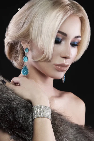 Siyah arka plan üzerine poz şık makyaj ve moda aksesuarları ile sarışın genç kadın portresi