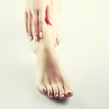 Beyaz arka plan üzerinde beyaz manikür ile kadın ayak görünümü Kapat