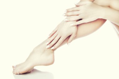 Beyaz arka plan üzerinde beyaz manikür ile ayak görünümü Kapat