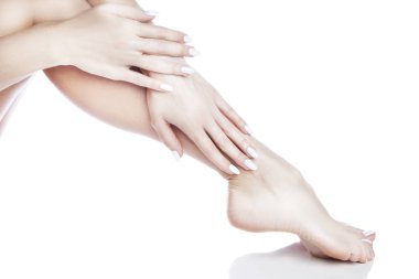 Beyaz arka plan üzerinde beyaz manikür ile ayak görünümü Kapat