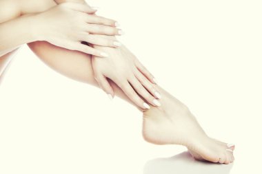 Beyaz arka plan üzerinde beyaz manikür ile ayak görünümü Kapat