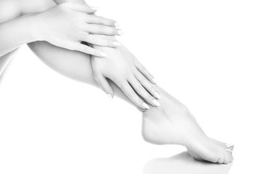 Beyaz arka plan üzerinde beyaz manikür ile ayak görünümü Kapat