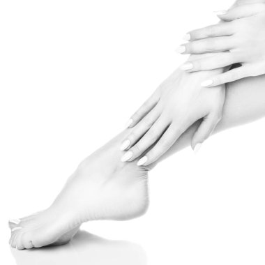 Beyaz arka plan üzerinde beyaz manikür ile ayak görünümü Kapat