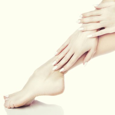 Beyaz arka plan üzerinde beyaz manikür ile ayak görünümü Kapat