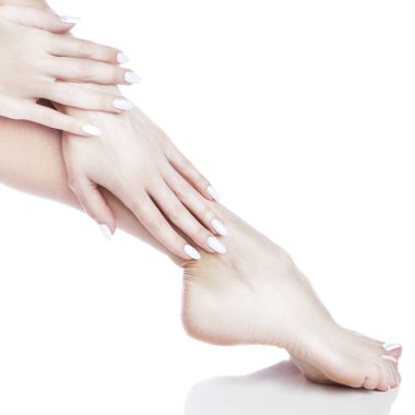 Beyaz arka plan üzerinde beyaz manikür ile ayak görünümü Kapat