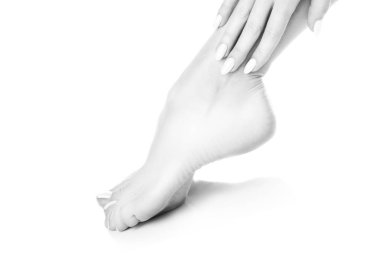 Beyaz arka plan üzerinde beyaz manikür ile ayak görünümü Kapat