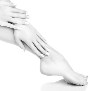 Beyaz arka plan üzerinde beyaz manikür ile ayak görünümü Kapat