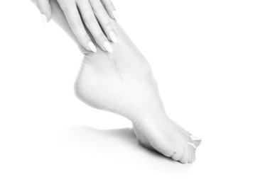 Beyaz arka plan üzerinde beyaz manikür ile ayak görünümü Kapat