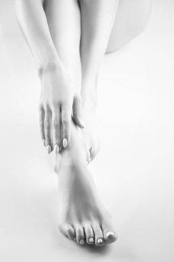 Beyaz arka plan üzerinde beyaz manikür ile kadın ayak görünümü Kapat