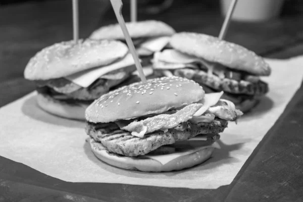 Fast food burgers with cheese in restaurant. Monochrome