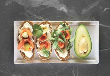 İtalyan kahvaltı tabağı Aocado ve küçük sandviçler somon ve peynirli bruschetto.