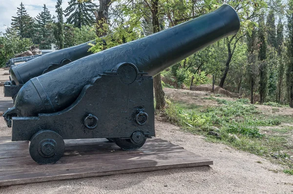 Old cannons on wooden carriages and defensive fort cores. Museum.