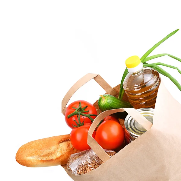 Paper bag with food supplies for the period of quarantine isolation on a white background. Delivery, donation, coronavirus, copyspace.