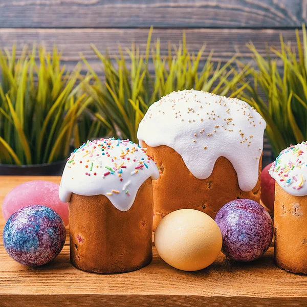 Easter cakes and Easter colored eggs on a wooden background. Religious holiday of bright Easter.