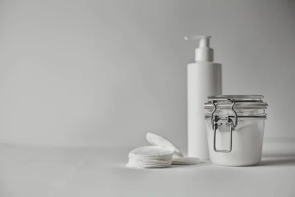 Güzel minimalist kavramsal tüm kompozisyon - şeffaf kavanoz ve plastik şişe ile pompa, metalik detaylarla tüm beyaz beyaz
