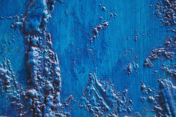 Bright turquoise blue painted textured surface made of construction foam on wood, creating various height and size elevations.