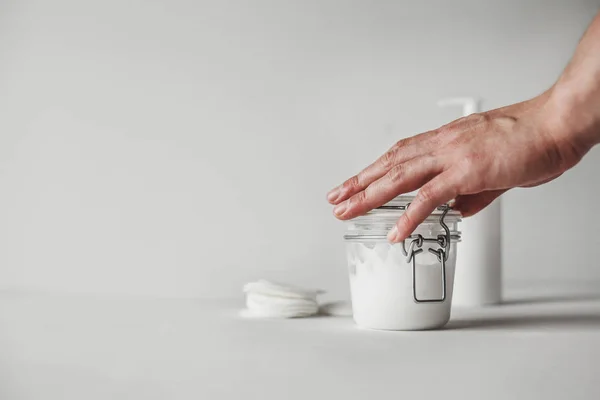 Mano Una Mujer Tocando Frasco Vidrio Transparente Lleno Crema Corporal — Foto de Stock