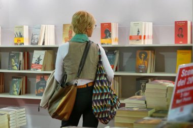 Uluslararası kitap fuarı Torino İtalya 'da 10 Mayıs 2019' da kütüphanede kitap okuyup kitap toplayan bir kadın
