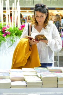 Uluslararası kitap fuarı Torino İtalya 'da 10 Mayıs 2019' da kütüphanede kitap okuyup kitap toplayan bir kadın