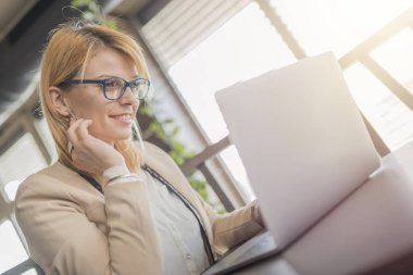 İş kadını laptop kahve dükkanında çalışıyor restoran. Çekici mutlu kız dizüstü bilgisayar çalışma için hazırlamak için kullanıyor. Gözlüklü güzel kız internet hakkında bilgi almak için arıyor.