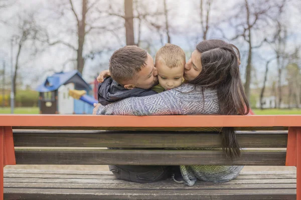 Ebeveynler çocuklarının parkta eğleniyor. Güzel aile eğleniyor dışında. Anne baba ile küçük oğulları ile sahada oynuyor. Sevimli küçük çocuk ailesiyle birlikte zevk. 