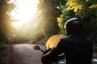 Yakışıklı ve çekici bir adam moto cl ile motosiklet sürüyor.