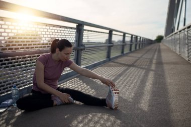 Gün batımı egzersizi güzel, sporcu kadınla. Kadın fitness koşusu, spor sağlık konsepti. Koşu yaparken müzik dinleyen kadın koşucu