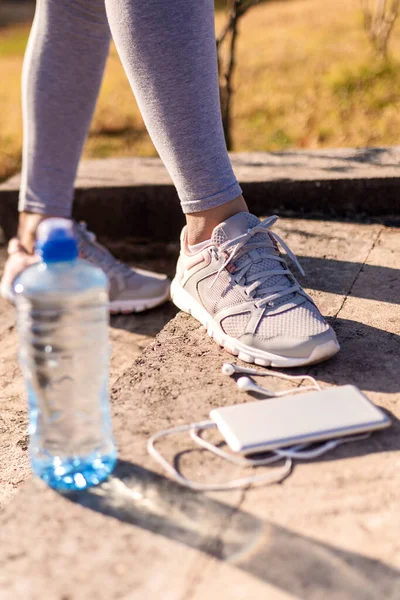 Koşu ayakkabıları, ayakkabı bağlayan kadın. Fitness, spor ve yaşam tarzı konsepti.