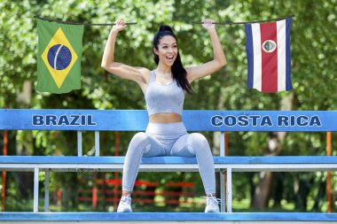 Brezilya ve Kosta Rika güzel seksi kız tarafından güneşli gün boyunca tutulan bayrakları