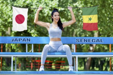 Japonya ve güneşli gün boyunca güzel seksi kız tarafından tutulan Senegal bayrakları