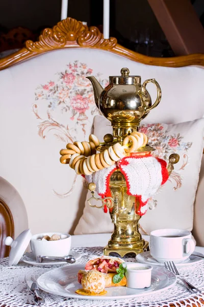 Russian tea drinking from a samovar with jam, bagels and shelves